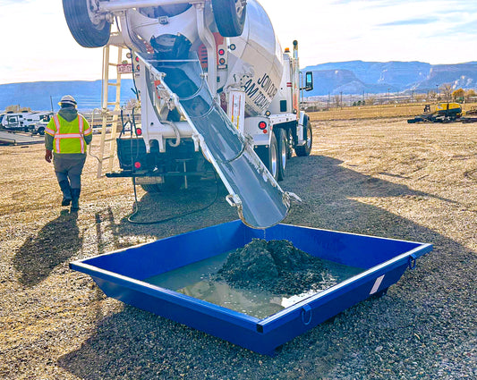 A concrete truck washing out into a concrete washout tub.