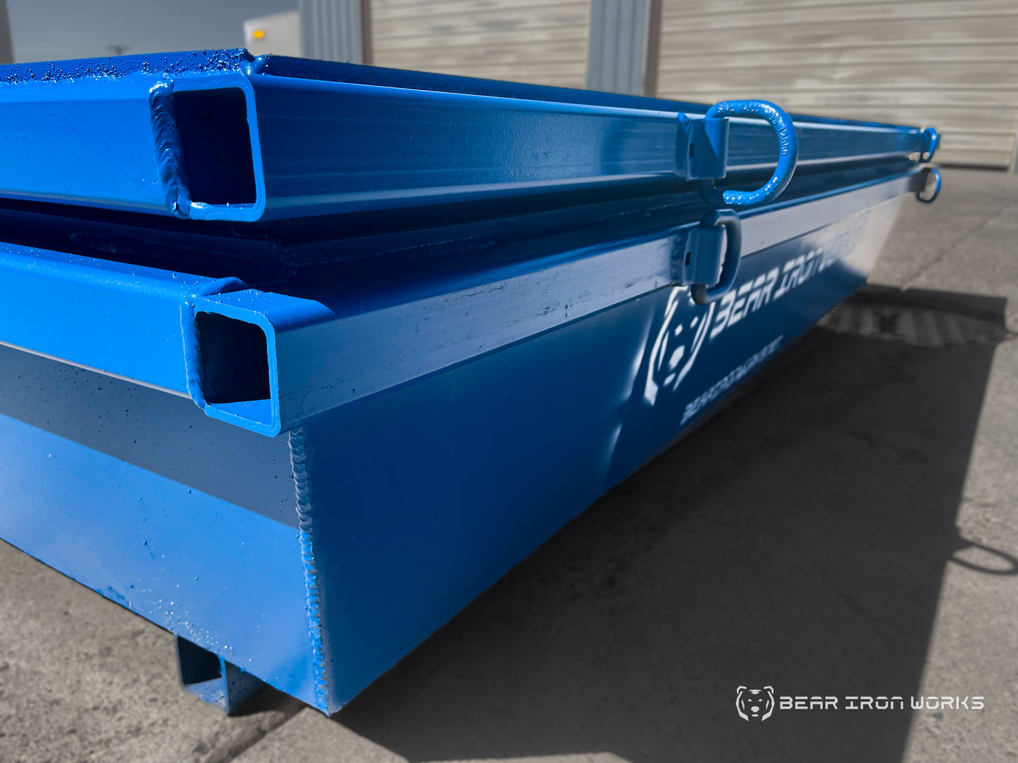 A corner shot of 2 blue concrete washout tubs nested together.