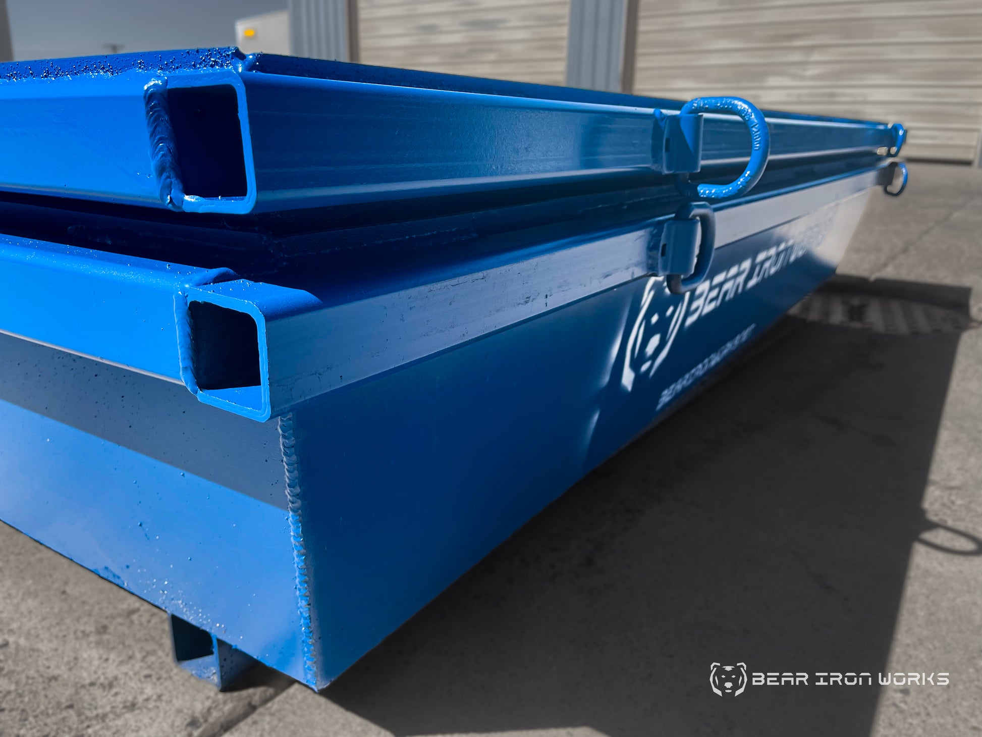 A corner shot of 2 blue concrete washout tubs nested together.