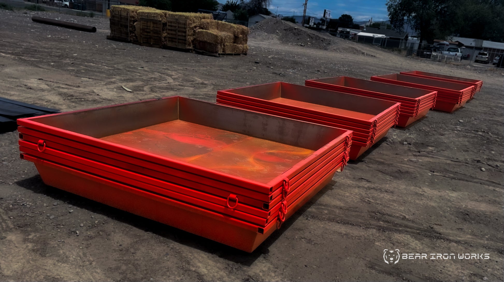 Multiple nested concrete washout tubs on a construction site.