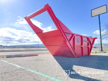 A red rock box, commonly used for bedding utilities, with a 7 cubic yard capacity. 